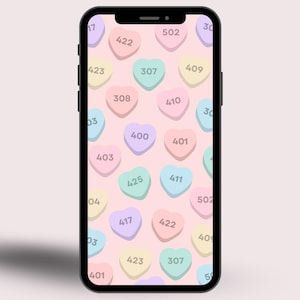May include: A smartphone displays a pink background with a pattern of pastel-colored heart-shaped candies. Each candy has a three-digit number in white. The phone is black with a rounded rectangular shape.