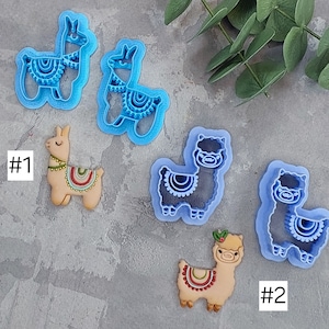 以下が含まれることがあります： 2つのラマのクッキー型セット、1つは青、もう1つは黒。各セットの隣には、デコレーションされたラマのクッキーがあります。青いセットは#1、黒いセットは#2とラベル付けされています。