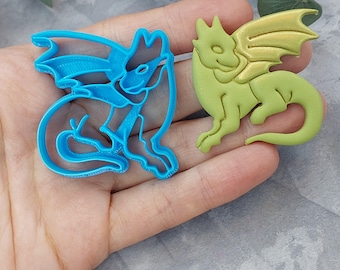 Könnte beinhalten: Zwei Ausstecher in Form von Drachen. Einer ist blau und der andere grün.