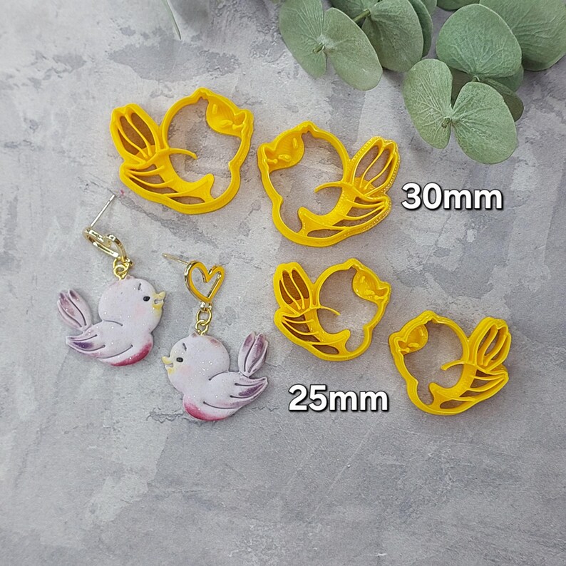 May include: Two pairs of yellow plastic bird-shaped cookie cutters. The larger cutters are 30 mm and the smaller cutters are 25 mm. Two pairs of earrings with a pink bird design are also shown.