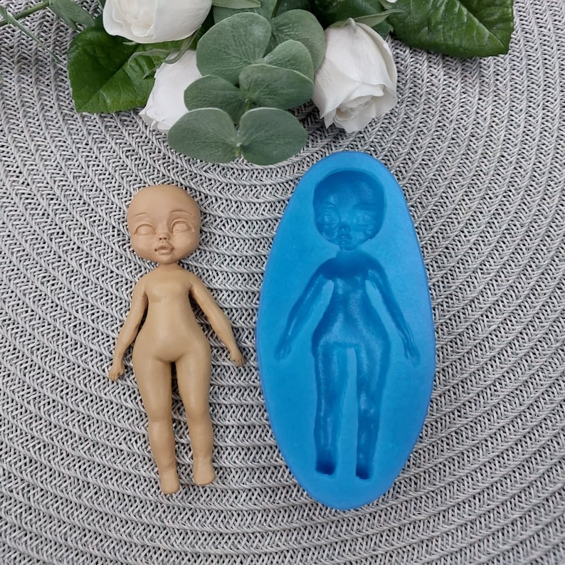 Puede incluir: Un molde de silicona azul para hacer una figura de mu&ntilde;eca. El molde tiene forma de persona con cabeza, brazos, piernas y torso. Se muestra una figura de mu&ntilde;eca terminada junto al molde.