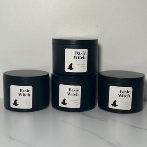 May include: Three black candle jars with white labels that say "Basic Witch" and a witch's hat graphic.