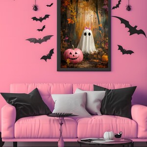 May include: A framed print of a ghost wearing a pink bow in a woodland setting. The ghost is standing next to a pink jack-o'-lantern. The print is hanging on a pink wall with black bats and a spider's web.