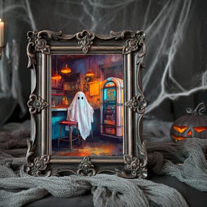 Puede incluir: Una obra de arte enmarcada con temática de Halloween representa un fantasma sentado en un bar con una máquina de discos. La obra de arte está en un marco ornamentado. La escena está ambientada en un bar con poca luz con un taburete rojo y una máquina de discos vintage. Una calabaza tallada está cerca.