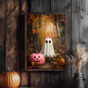 May include: A framed painting of a white ghost with a pink bow in an autumn woodland setting. A pink jack-o'-lantern sits in the foreground.