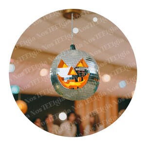 May include: A silver disco ball with a jack-o'-lantern face hanging from the ceiling. The ball is surrounded by colorful lights and a blurred background of people.