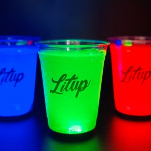 May include: Three clear plastic cups with glowing liquid inside. The cups are labeled "Litup" and the liquid glows blue, green, and red.