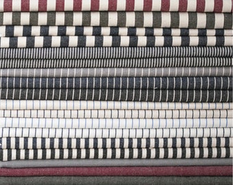 May include: A stack of fabric swatches with various striped patterns in black, white, blue, and red.
