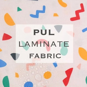 May include: A close-up of a white fabric with a colorful geometric pattern. Water droplets are visible on the fabric, demonstrating its water-resistant properties. The text "PUL Laminate Fabric" is printed on a white rectangle.