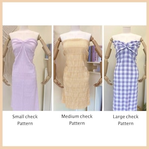 Peut inclure: Trois robes sans bretelles avec des motifs vichy de différentes tailles. Les robes sont dans des tons de violet, jaune et bleu. La robe de gauche a un motif vichy petit, la robe du milieu a un motif vichy moyen et la robe de droite a un motif vichy grand.