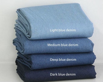 May include: Four different shades of blue denim fabric stacked on top of each other. The fabric is folded in half and the labels read "Light blue denim", "Medium blue denim", "Deep blue denim", and "Dark blue denim".