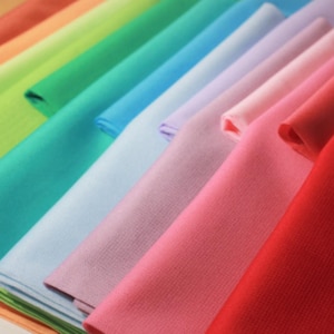 Peut inclure: Un ensemble d'échantillons de tissu colorés dans des tons d'orange, vert, bleu, violet, rose et rouge.