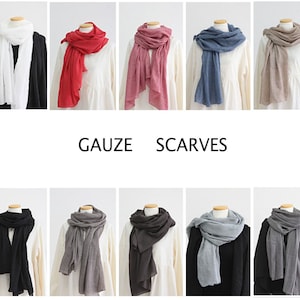 May include: Ten different gauze scarves in various colors, including white, red, pink, blue, and gray. The scarves are arranged in two rows of five, with the word "GAUZE" and "SCARVES" printed below the top row.