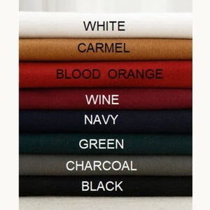 May include: A stack of fabric swatches in various colors, including white, camel, blood orange, wine, navy, green, charcoal, and black.