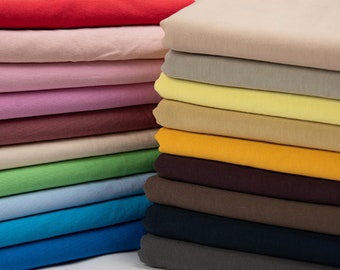 May include: A stack of fabric swatches in various colors, including red, pink, beige, yellow, orange, brown, green, blue, and navy.