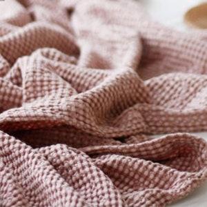 Peut inclure: Une couverture moelleuse en tissu gaufré rose. La couverture est faite d'un tissu texturé avec un motif en forme de gaufre.