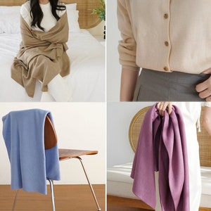 May include: Four different coloured scarves, one brown, one light blue, one purple, and one beige. The scarves are made of a soft, knitted fabric.