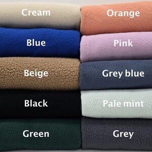 May include: A stack of ten fabric swatches in different colours, including cream, orange, pink, grey blue, pale mint, grey, beige, blue, black, and green.