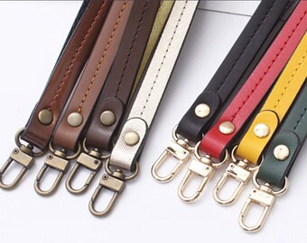 May include: A set of eight leather straps with metal clasps. The straps are in various colors, including black, red, yellow, green, brown, and white. The straps are all about 1 cm wide and have a stitched design.