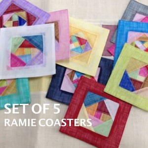 May include: Set of five colorful fabric coasters with a geometric pattern. The coasters are made of ramie and have a textured surface. "SET OF 5 RAMIE COASTERS" is written in white text on a light beige background.