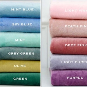 May include: A stack of fabric swatches in various shades of blue, green, pink, and purple. The swatches are labelled with the colour names: Mint Blue, Sky Blue, Mint, Grey Green, Olive, Green, Light Pink, Peach Pink, Deep Pink, Light Purple, and Purple.