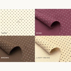 May include: Four fabric swatches with white polka dots on different coloured backgrounds. The colours are ivory, wine, brown, and light beige. Each swatch is folded in half to show the fabric's texture.