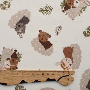 Puede incluir: Tela blanca con un patrón repetido de animales marrones y beige. Los animales incluyen un oso, un ciervo y un conejo. Los animales están todos durmiendo y tienen un estilo lindo y de dibujos animados. La tela es perfecta para hacer ropa de bebé, mantas u otras manualidades.