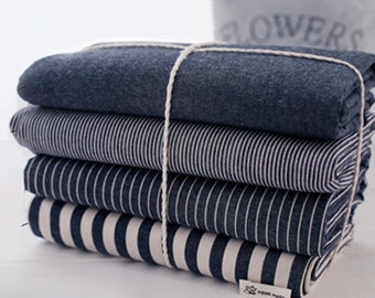 May include: A stack of four fabric swatches in various blue and white striped patterns. The top swatch is a solid dark blue color.