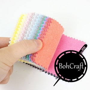 May include: A collection of colourful fabric swatches in various shades of pink, yellow, blue, and green. The fabric is a soft, textured cotton. The swatches are arranged in a fan shape and held in a hand. The image includes the text "BohCraft" in a black circle with a needle and thread.