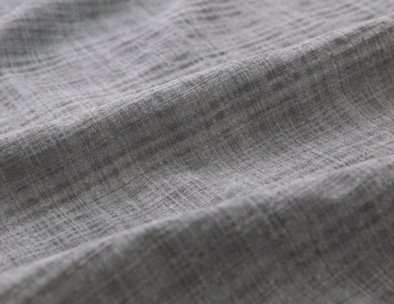 May include: Close-up of a gray textured fabric with a subtle woven pattern.