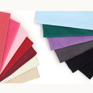 May include: A collection of ten fabric swatches with a polka dot pattern in various colours, including pink, red, burgundy, beige, light blue, green, purple, grey, and black.