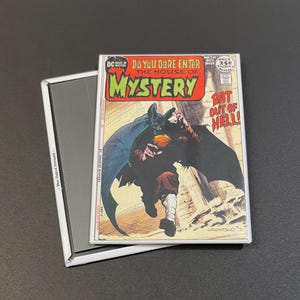 May include: A vintage comic book cover featuring a bat-like creature with a human-like face. The cover is titled "Do You Dare Enter The House of Mystery" and "Bat Out of Hell!" The comic book is from DC Comics and is issue number 218.