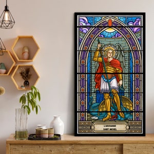 Könnte beinhalten: Ein Buntglasfenster, das den Erzengel Michael zeigt, wie er einen Drachen besiegt. Das Fenster ist schwarz gerahmt und hat ein blaues, rotes und goldenes Farbschema. Der Text "L'Archange Saint Michel" befindet sich am unteren Rand des Fensters.
