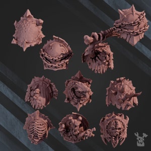 Könnte beinhalten: Ein Set aus zehn detaillierten, 3D-gedruckten, beigefarbenen Miniaturschilden mit verschiedenen Designs, darunter Schädel, Ketten und Stacheln. Die Schilde sind für Tabletop-Spiele oder das Bemalen von Miniaturen gedacht.