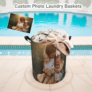 May include: A brown laundry basket with a photo of a family of three printed on it. The photo shows a woman holding two children, a boy and a girl, in a field. The basket is sitting on a patio next to a swimming pool.