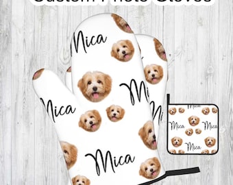 May include: A set of two white oven mitts and a matching pot holder with a repeating pattern of a dog's face and the name "Mica" printed in black.