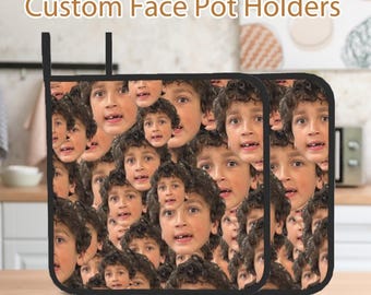Puede incluir: Dos agarraderas de olla negras con un patrón de la cara de un niño pequeño repetido en toda la superficie. El texto "Custom Face Pot Holders" se muestra en la parte superior de la imagen.