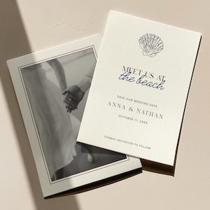 May include: Wedding invitation with a seashell illustration and the text "Meet us at the beach." The invitation includes the names Anna & Nathan and the wedding date, October 11, 20XX. A black and white photo of a couple holding hands is also included.