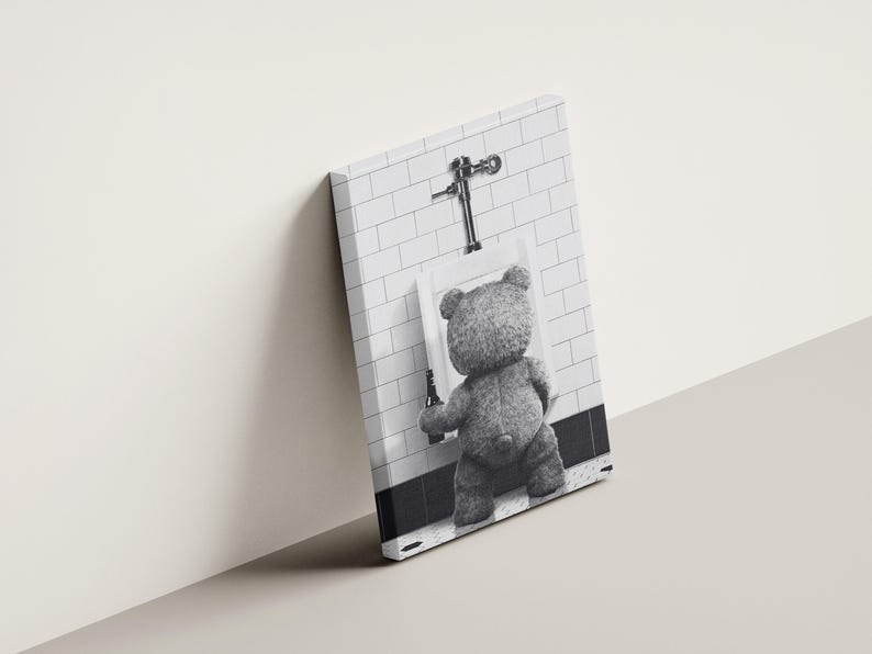 Quirky bathroom wall art with a teddy bear at a urinal, combining humor and minimalist photography.
