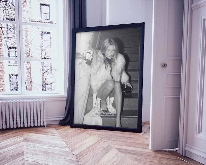 Vintage Kate Moss canvas poster featuring her iconic smoking on stairs pose. A perfect addition to any 90s fashion lover's decor, black and white photography style for a retro, chic vibe. Ideal for celebrity wall art enthusiasts and retro home decor.
