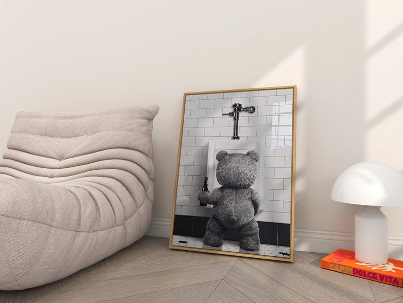 Black and white novelty wall art featuring a teddy bear drinking beer in a humorous bathroom setting.