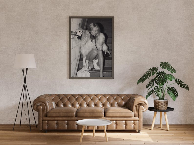 Vintage Kate Moss canvas poster featuring her iconic smoking on stairs pose. A perfect addition to any 90s fashion lover's decor, black and white photography style for a retro, chic vibe. Ideal for celebrity wall art enthusiasts and retro home decor.