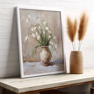 May include: A framed painting of a white flower bouquet in a brown ceramic vase. The flowers are arranged in a loose, natural style and the background is a soft, muted brown.