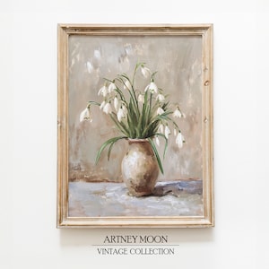 May include: A framed painting of a white flower bouquet in a brown vase. The flowers are arranged in a loose, natural style and the background is a soft, muted gray. The painting is signed "Artney Moon Vintage Collection".