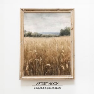 May include: A framed painting of a field of wheat with a distant landscape in the background. The painting is in a light wood frame and has a muted color palette.