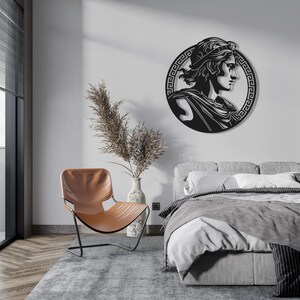 May include: Black metal wall decor featuring a profile of a person wearing a crown, surrounded by a Greek key design.