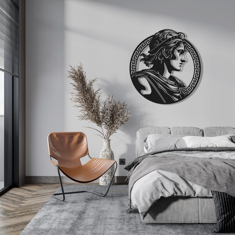 May include: Black metal wall decor featuring a profile of a person wearing a crown, surrounded by a Greek key design.