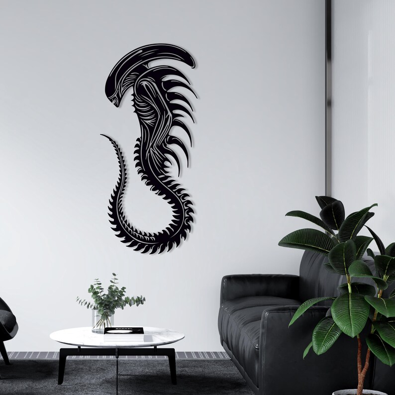 May include: Black alien creature wall decal with a detailed design. The decal is mounted on a white wall in a living room setting.