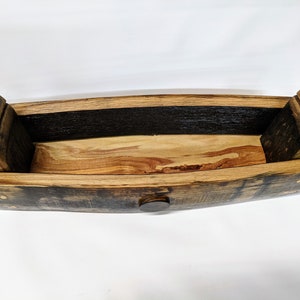 May include: A wooden rectangular box made from reclaimed wine barrel staves. The box is open and the inside is lined with light wood. The box has a dark brown stain and brass accents.
