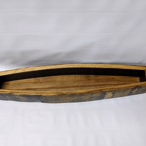 K&ouml;nnte beinhalten: Ein Holztablett aus einer wiederverwendeten Fassdauben. Das Tablett ist braun und hat eine nat&uuml;rliche Holzoptik. Es hat eine schwarze Stoffauskleidung im Inneren.